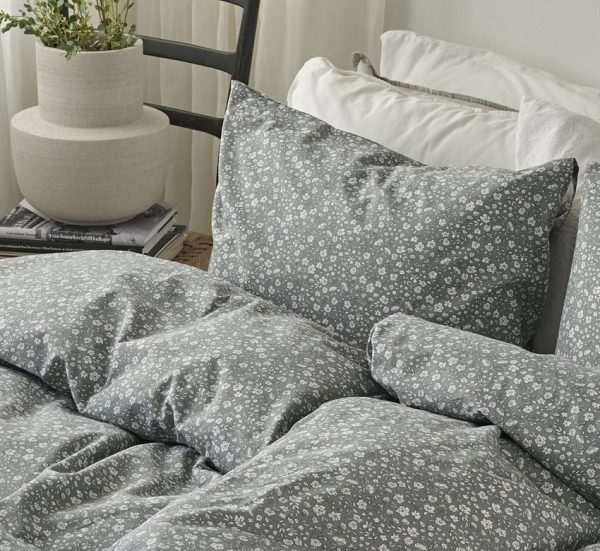 Mörkgrå sänggavel med vita blommor, stilrent och mysigt sovrum.