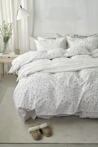 1. Säng med vit, mönstrad sängklädsel från Sängfabriken, mysig och stilren.