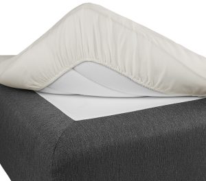 Lakanpassning på säng av hög kvalitet för optimal komfort.