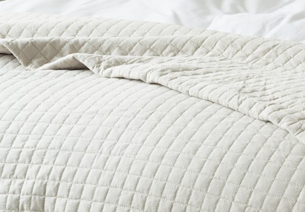 Högkvalitativt bäddset i krämfärgat tyg för bekvämt sovande.
