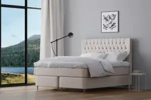 Högkvalitativ platsbyggd säng med galonklädd eller textilklädd sänggavel.