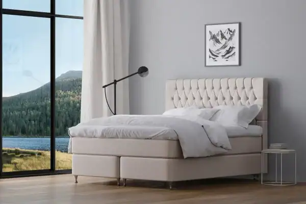 Högkvalitativ platsbyggd säng med galonklädd eller textilklädd sänggavel.