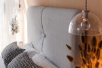 Sängfabriken sänggavel i ljusgrått tyg för modern sovrumsstil.