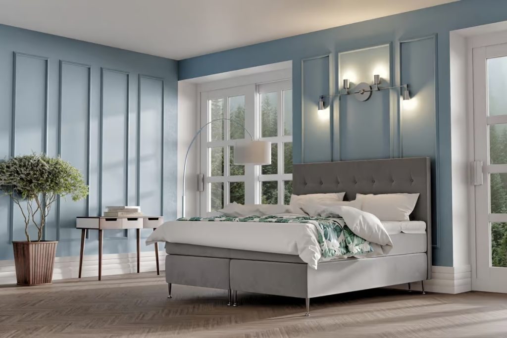 Elegant blå väggdekoration med säng från Sängfabriken i modern sovrumsmiljö.