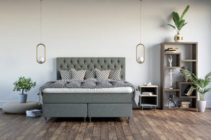 Sängfabriken säng i modern sovrumsinredning med grönt huvudgavel och växter.