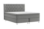 Säng med grått, tuftat huvudgavel och modern design.