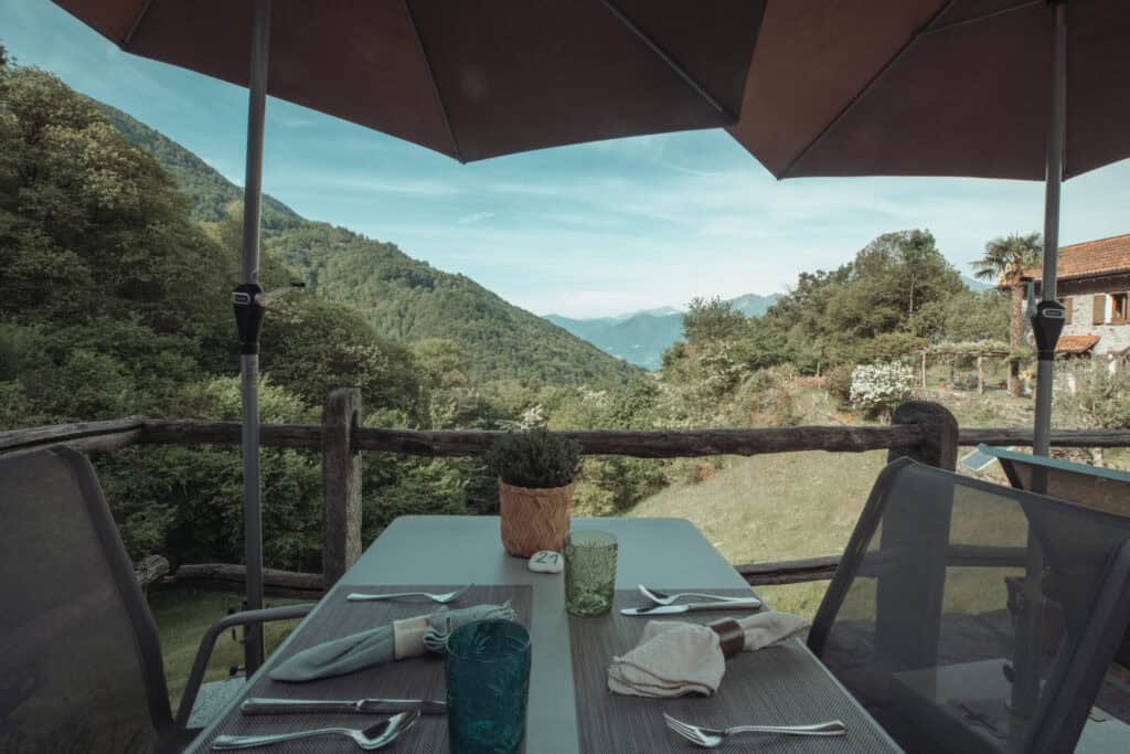Outdoor dining terrace at Sass da Grüm overlooking the surrounding nature in Ticino