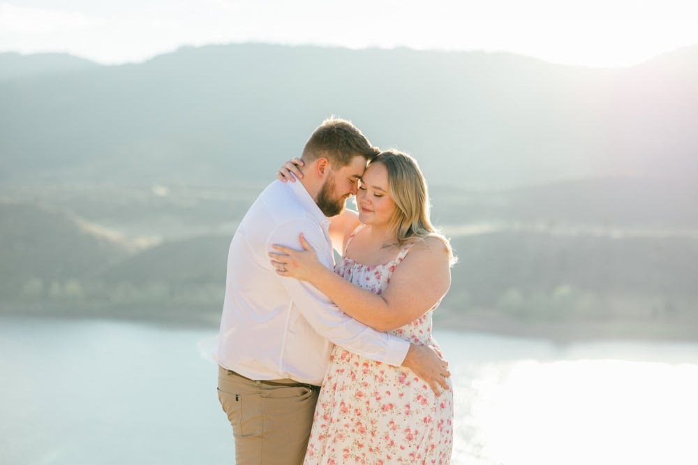 Couple cuddling into each other romantically during their engagement session at Horsetooth in Fort Collins