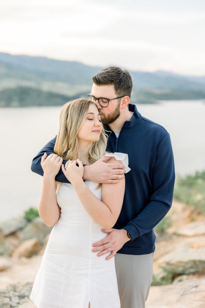 Couple cuddling with guy kissing her head