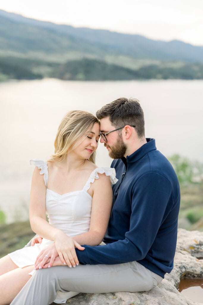 couple forehead to forehead with lake in background