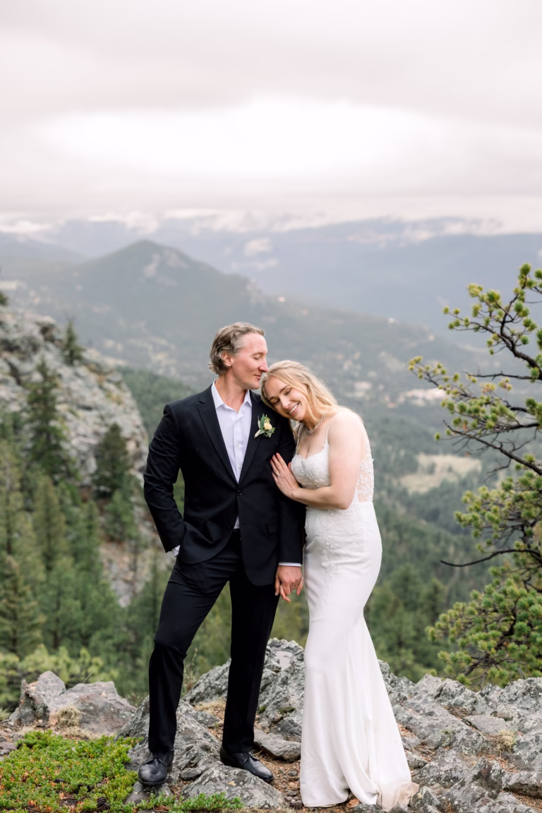 Bride and Groom cuddling on top of a mountain