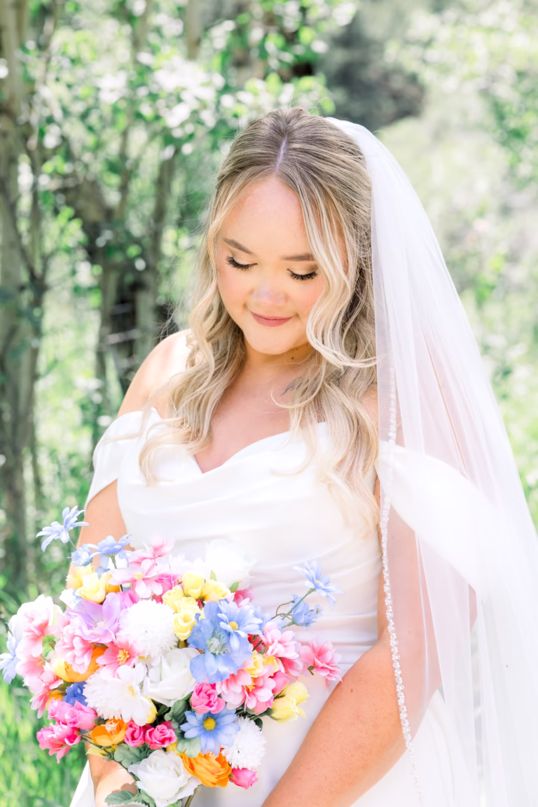 Beautiful bride looking down at her flower boquet