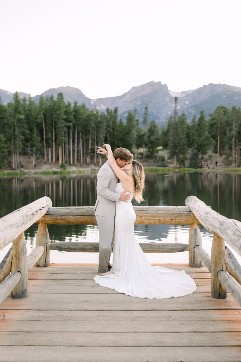 bride and groom kissing on bride with beautiful lake and mountain views