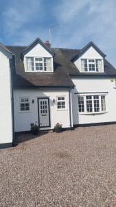 Bright white painted house exterior with black trim, showcasing professional decorating services.