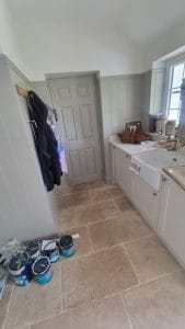 Bright kitchen with painted white cabinetry and beige tiled flooring, showcasing professional decorating by S Bond Decorating.