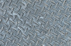 Scrap metal surface with diamond plate pattern for recycling and metal collection.