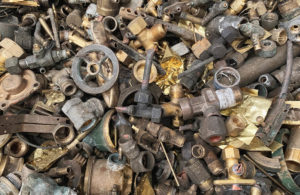 Assorted scrap metal pieces including valves, fittings, and hardware for recycling.