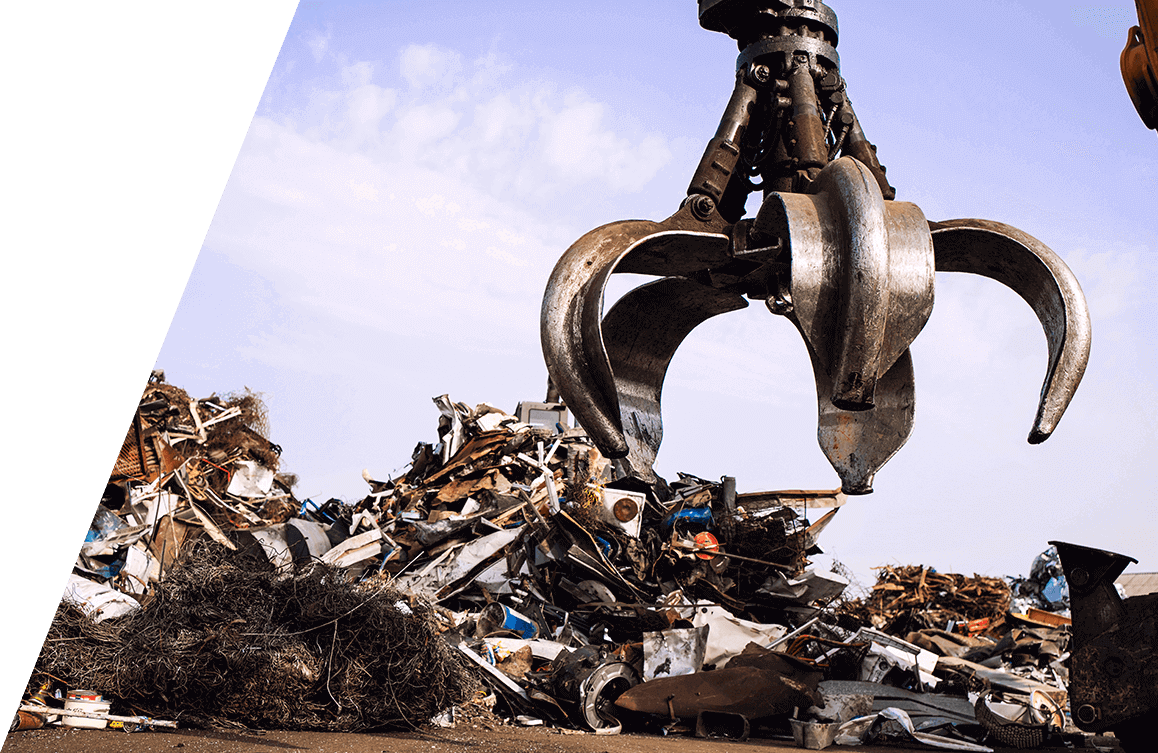 Heavy-duty scrap metal claw lifting scrap metal at recycling yard.