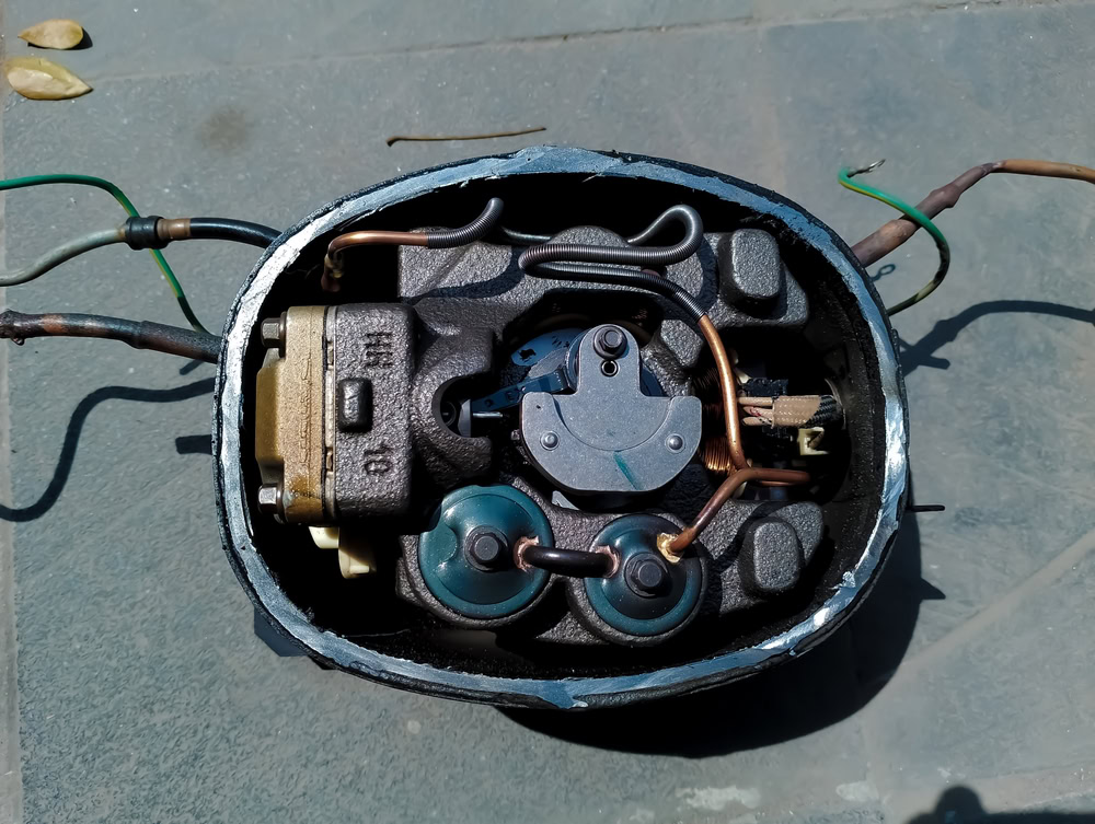 Refrigerator compressor for scrap metal recycling, showing internal components.