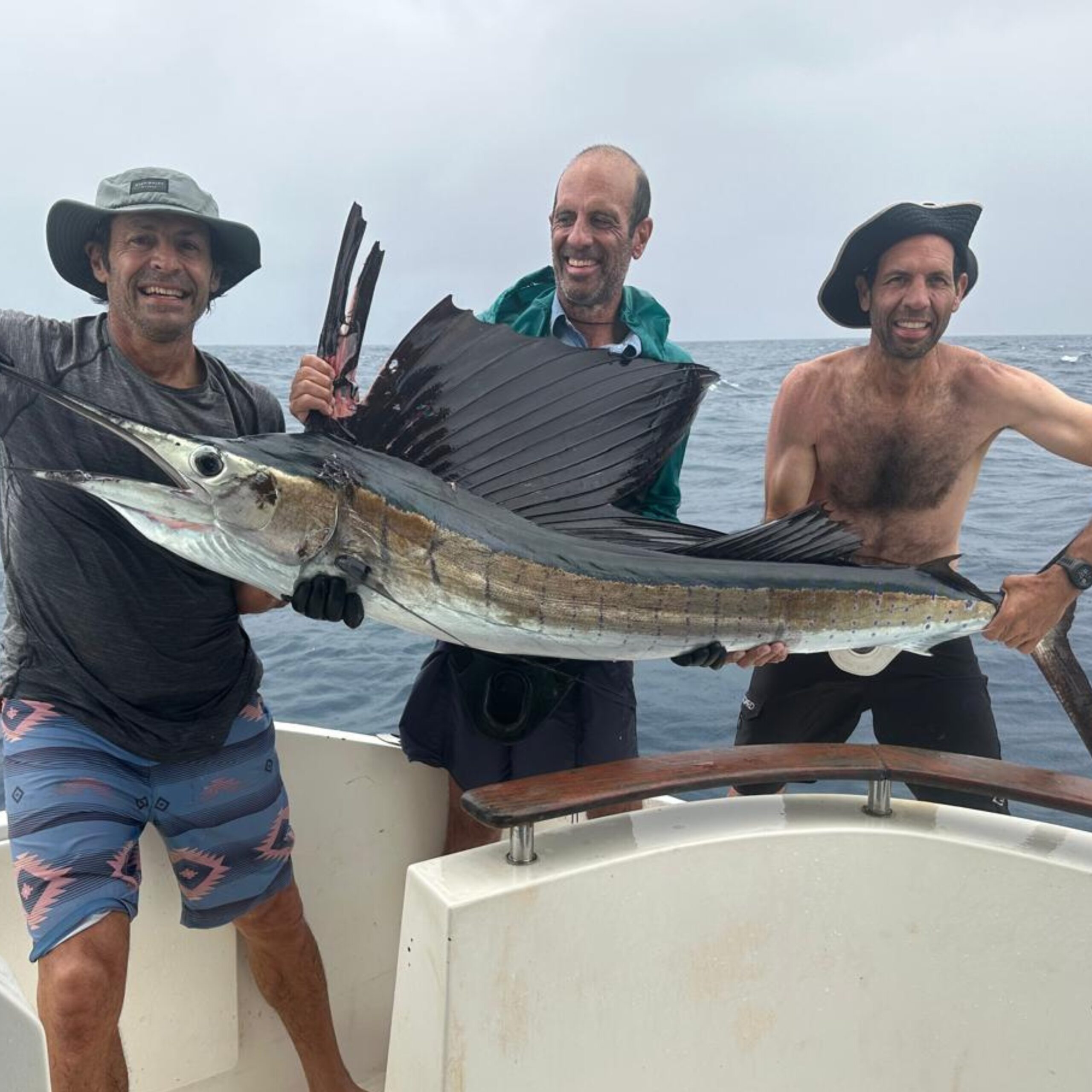 Anglers posing briefly with a sailfish at African Banks Seychelles before release