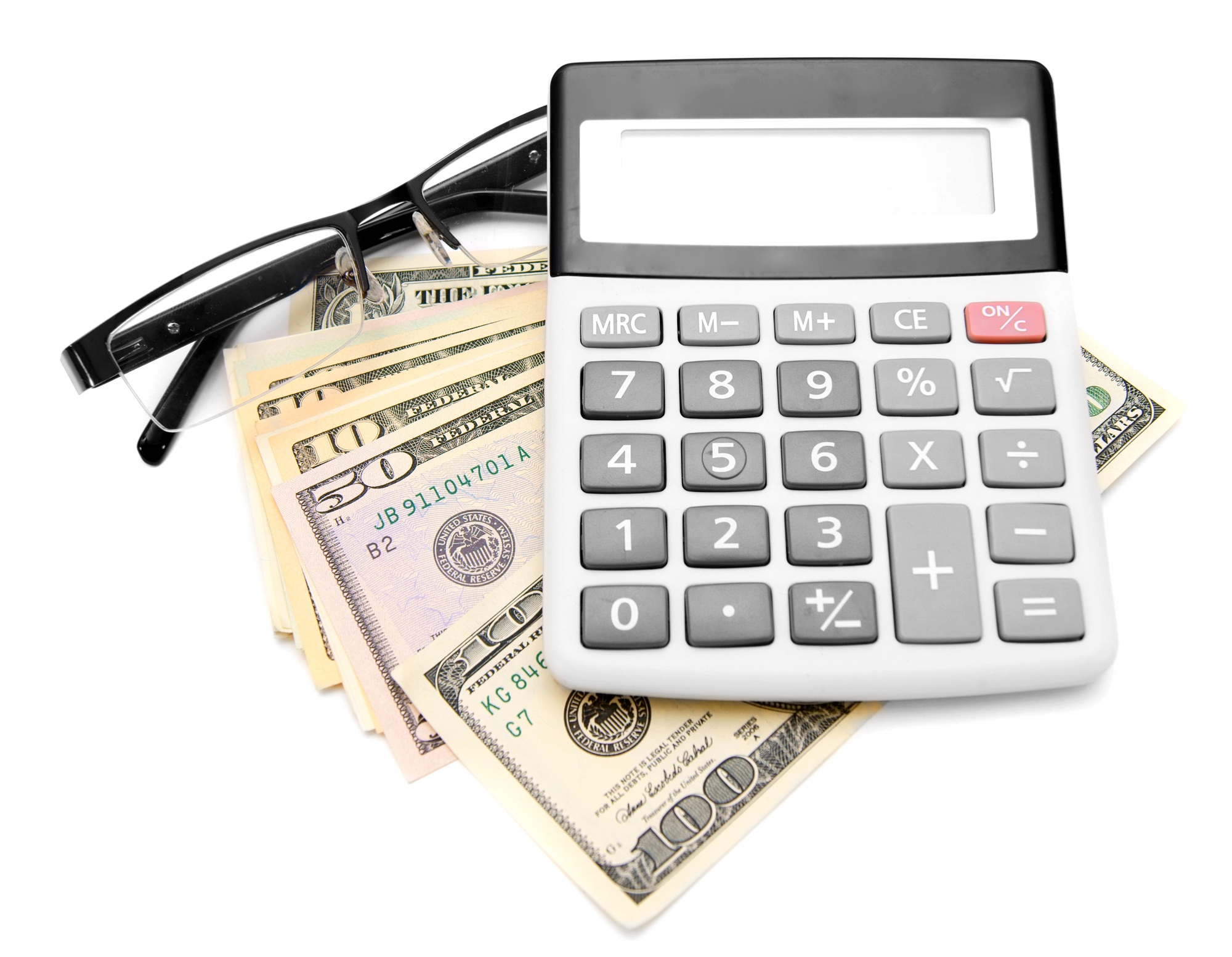 Calculator and glasses on a pack of dollars.