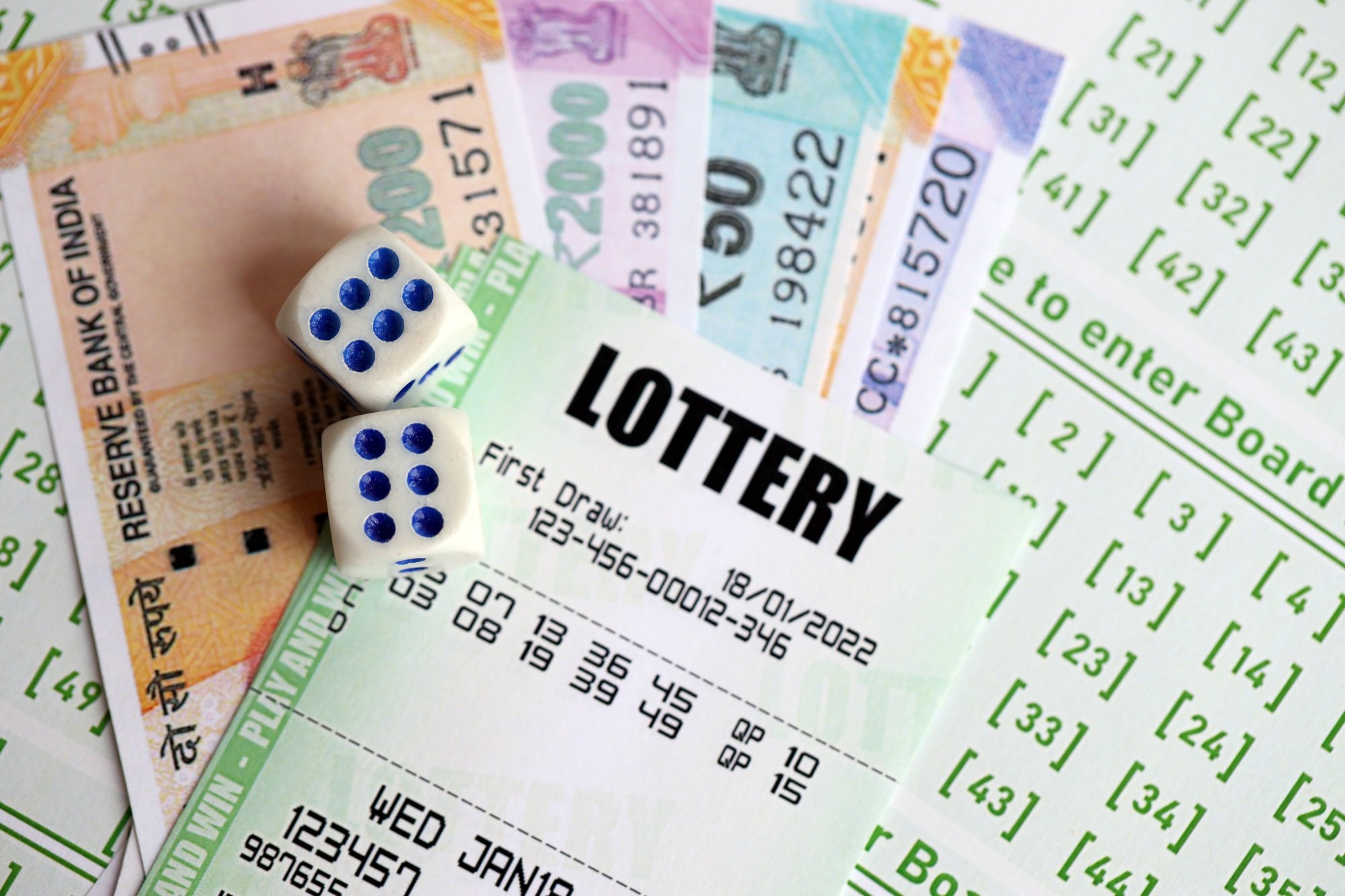 Green lottery tickets and indian rupees money bills on blank with numbers for playing lottery