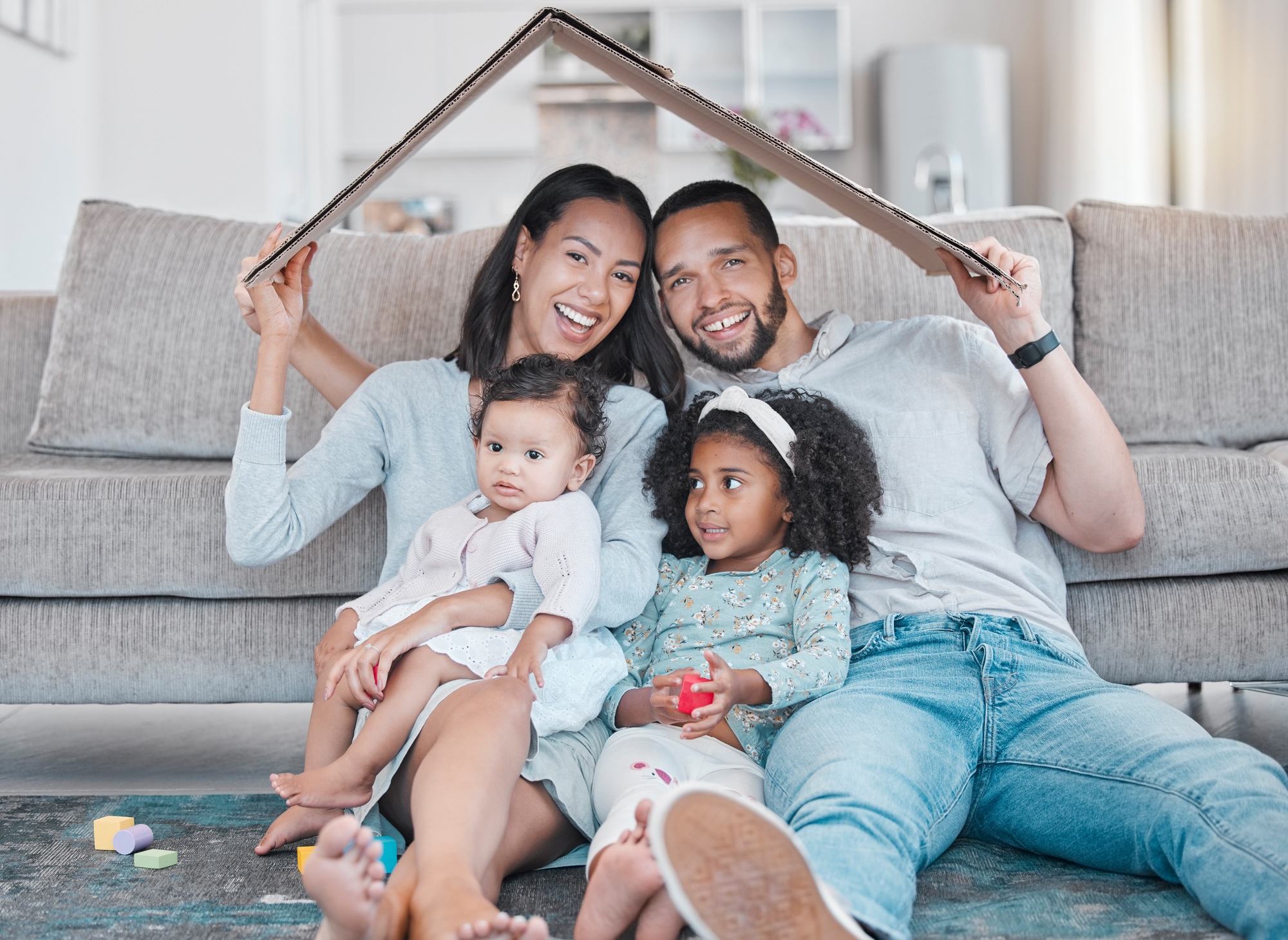 Happy family, new house and cardboard roof in living room, mortgage loan and investment security fo