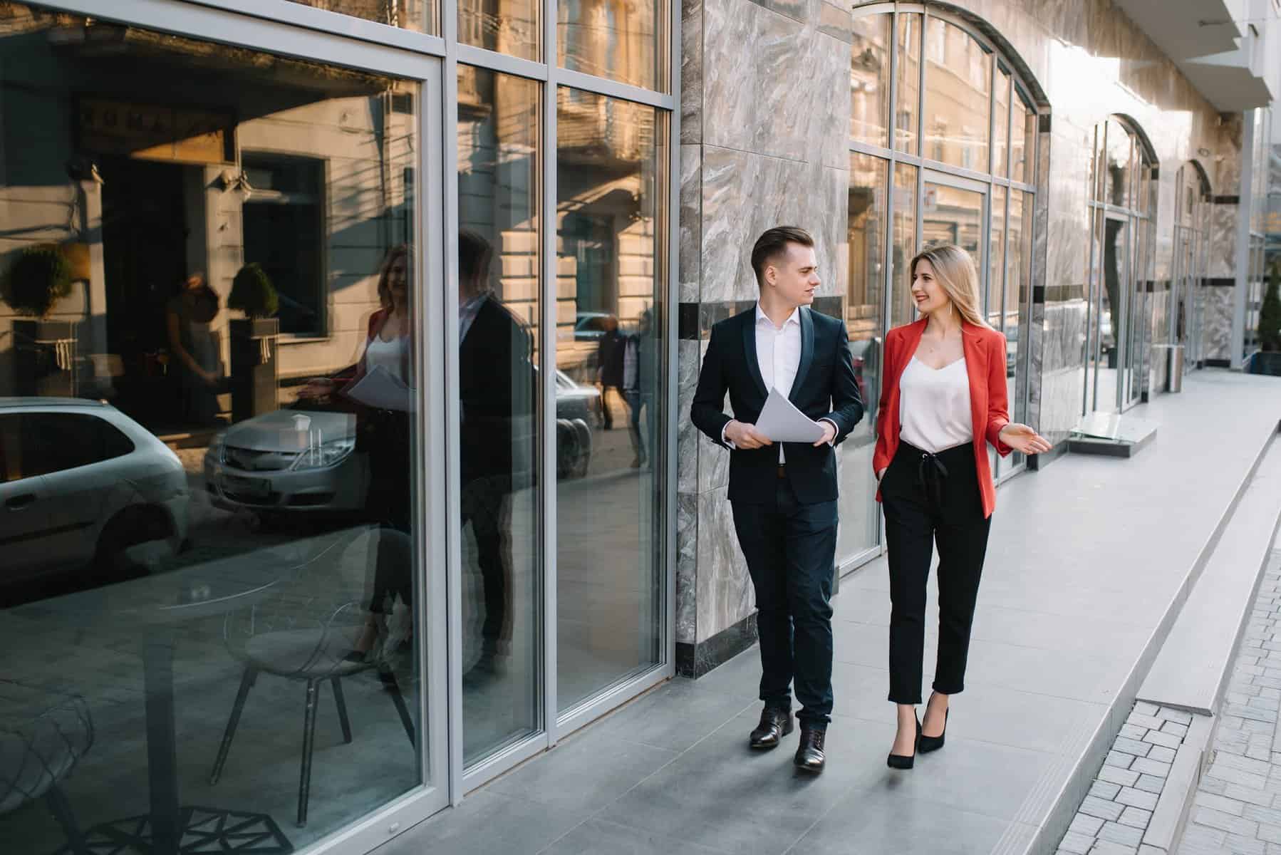 Two confident business colleagues walking on office terrace.