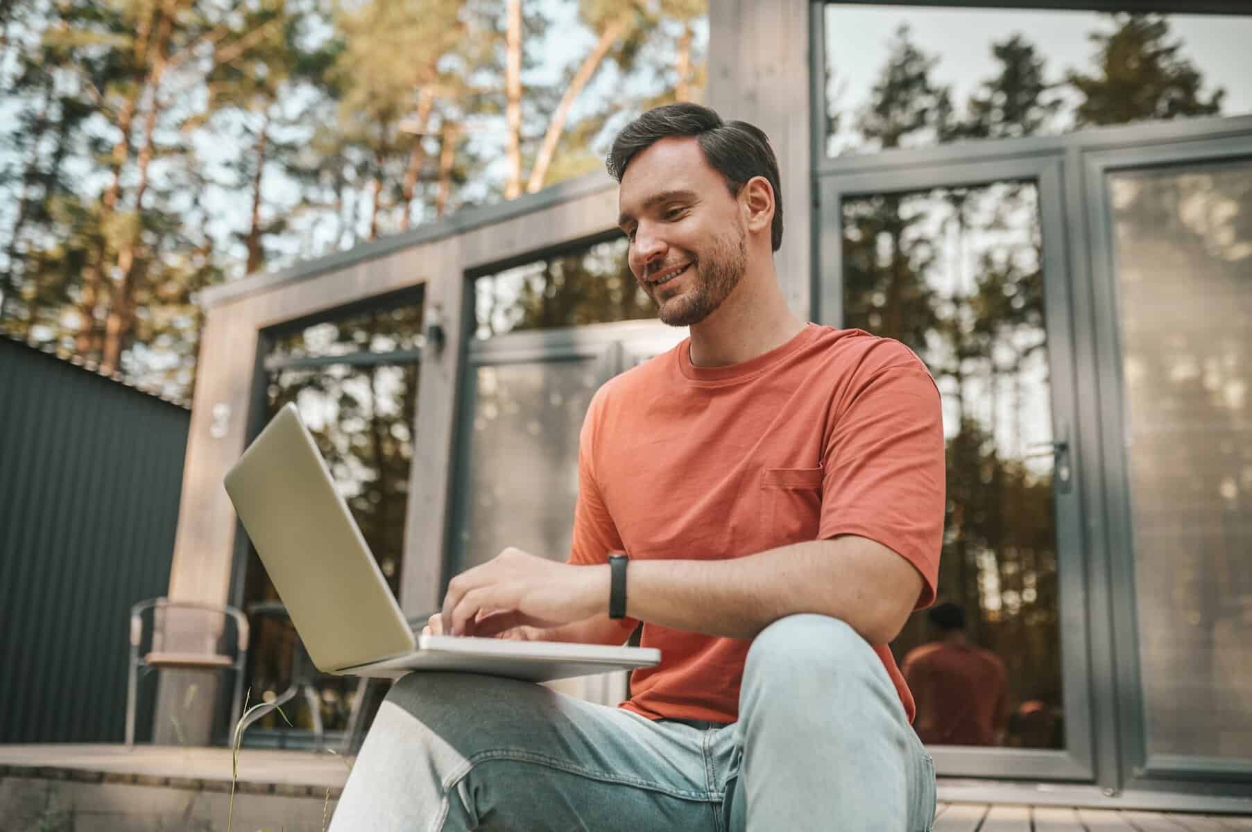 Young man feeling positive and working on a laptop