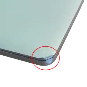 Coin de coin d'un ordinateur portable avec un dommage visible à l'angle inférieur droit.