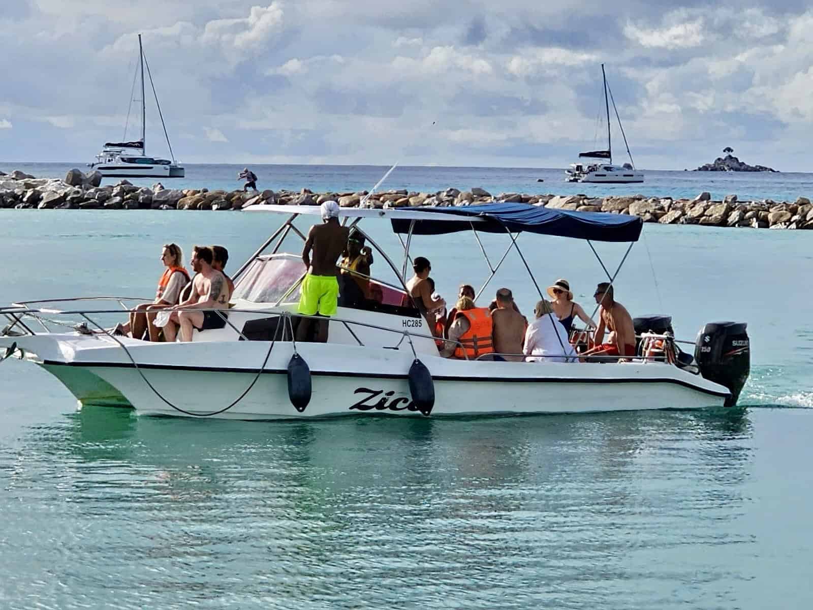 Zico boat with guests anchored near a beach