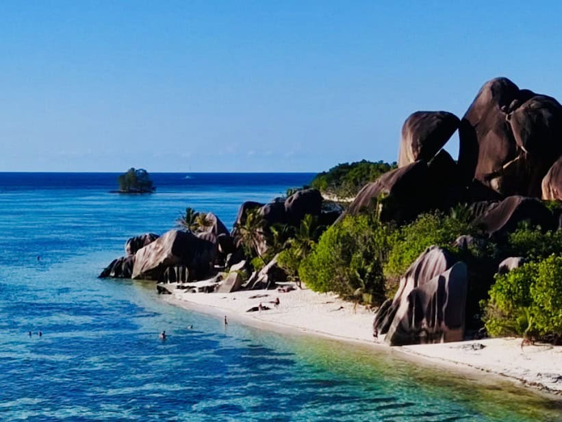 Seychelles beach with granite rocks, turquoise water and tropical trees