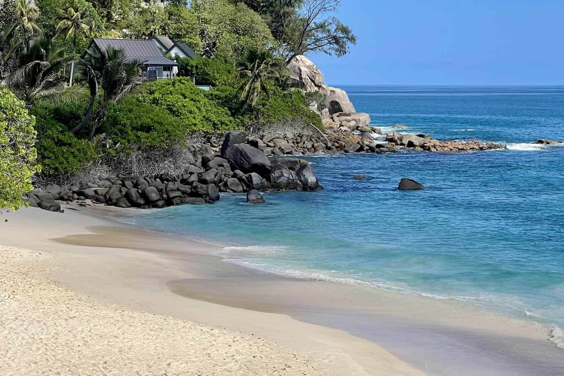EN: Carana Beach, Mahé — turquoise water and granite boulders | FR : Carana Beach, Mahé — eau turquoise et rochers granitiques