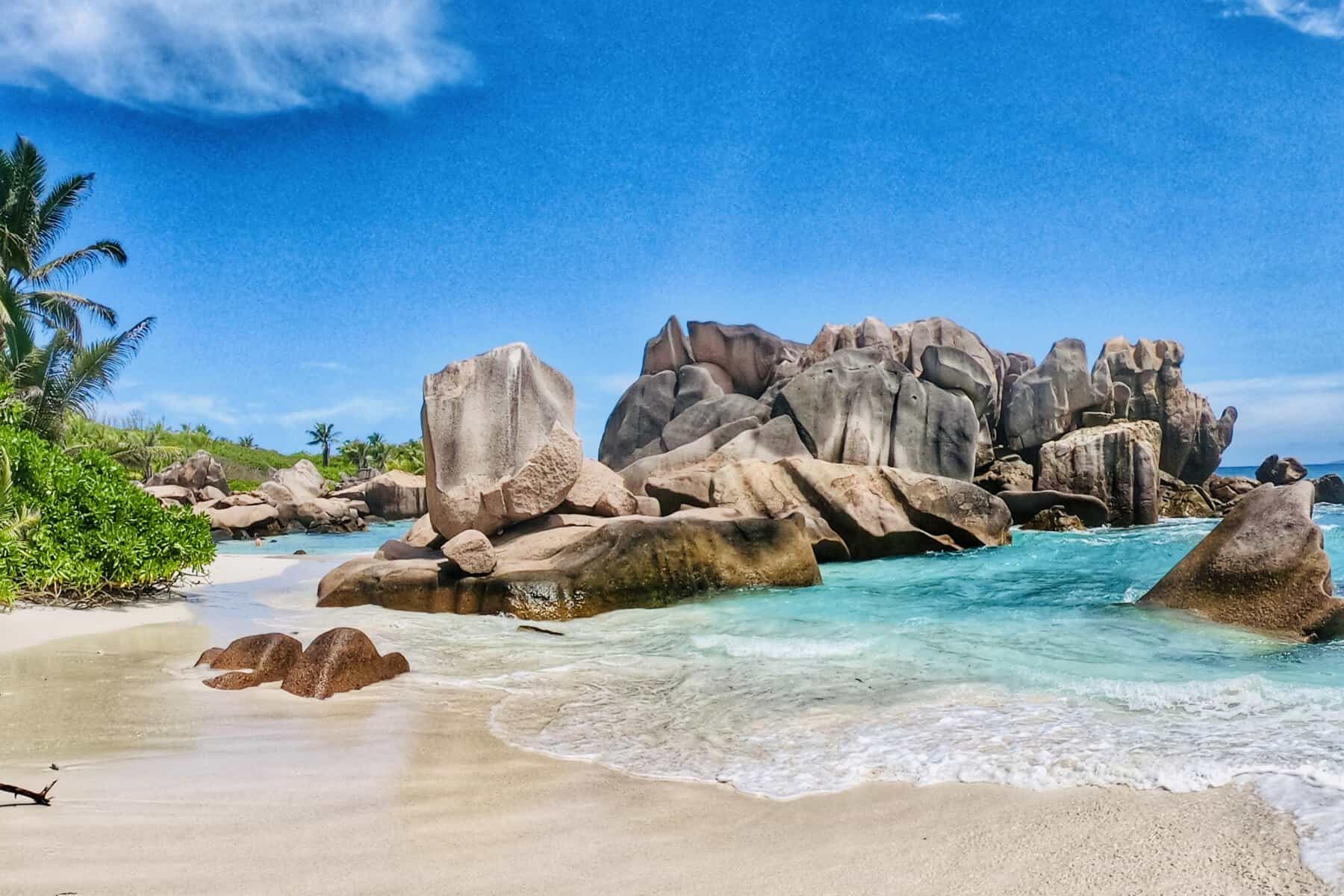 EN: Anse Cocos, La Digue — wild cove with natural rock pools and turquoise water (hike-in only) | FR : Anse Cocos, La Digue — crique sauvage avec bassins naturels et eau turquoise (accès à pied uniquement)
