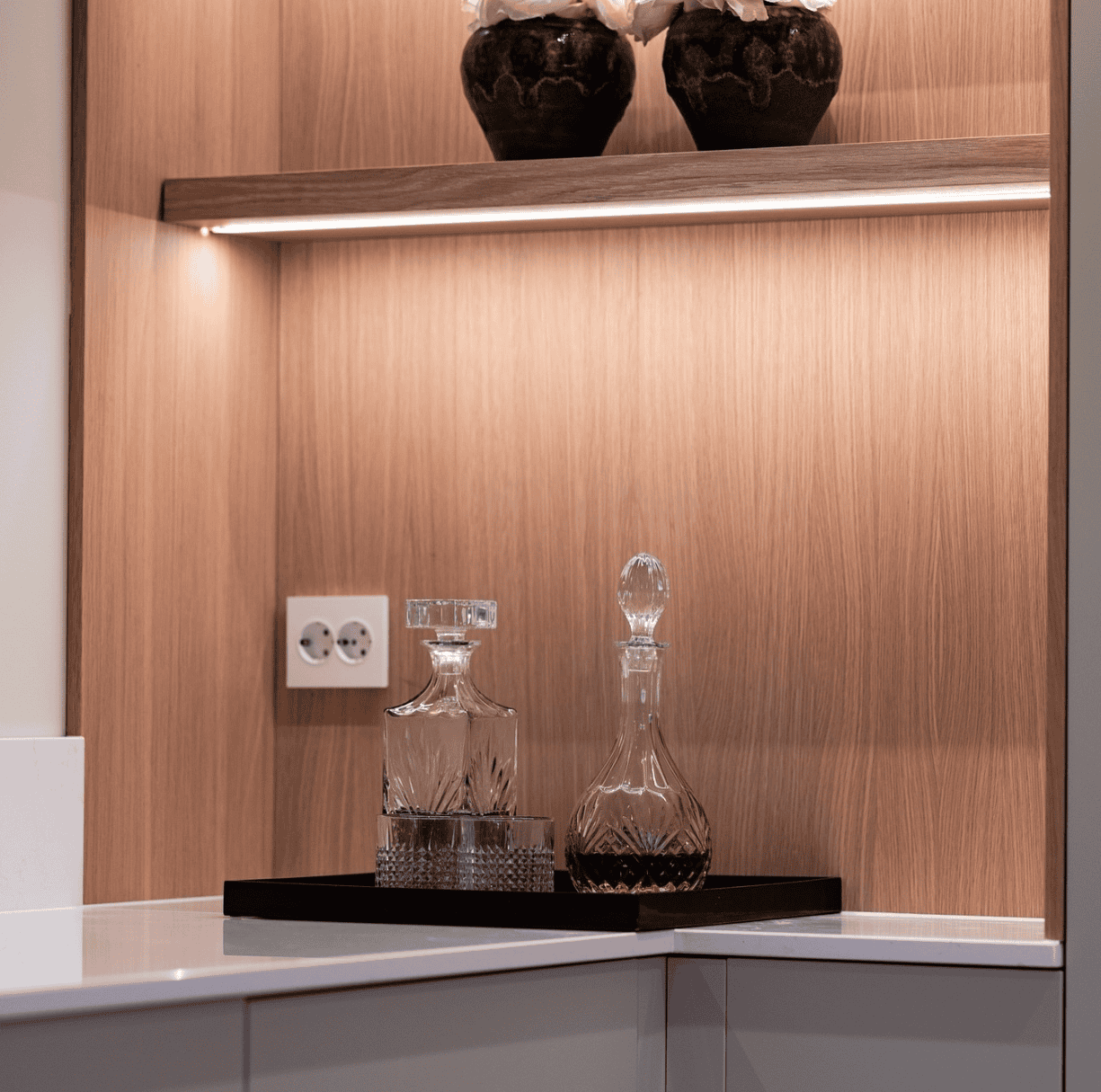 Fyrstikkontakt og lyspærer i moderne kjøkken. Elegant innredning med belysning og dekorative glasskrukker.