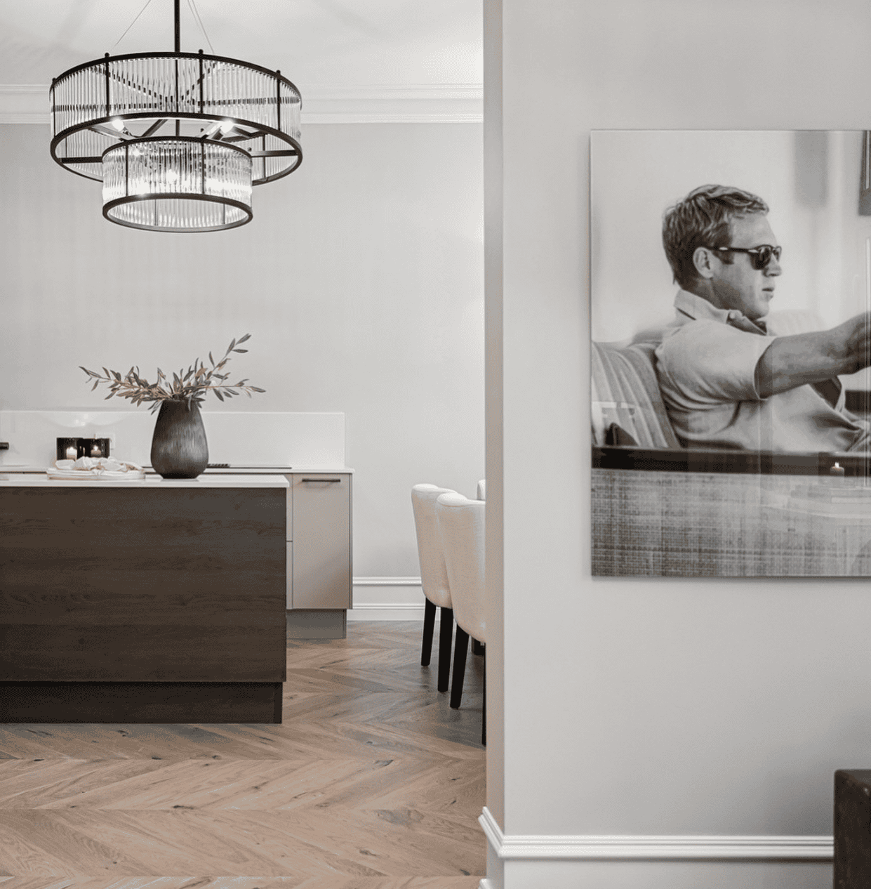 Gulvlampe i stue med elegant lysekron i taket og moderne dekorasjoner.