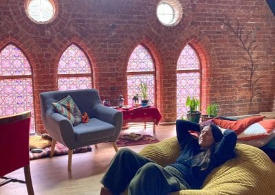 Person relaxing in cosy room with brick walls.