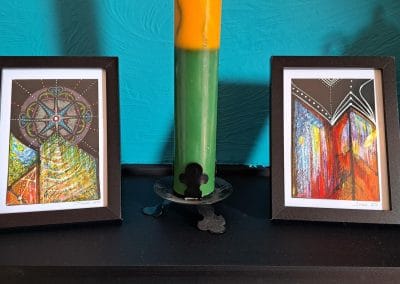 Colourful abstract paintings in black frames on display.