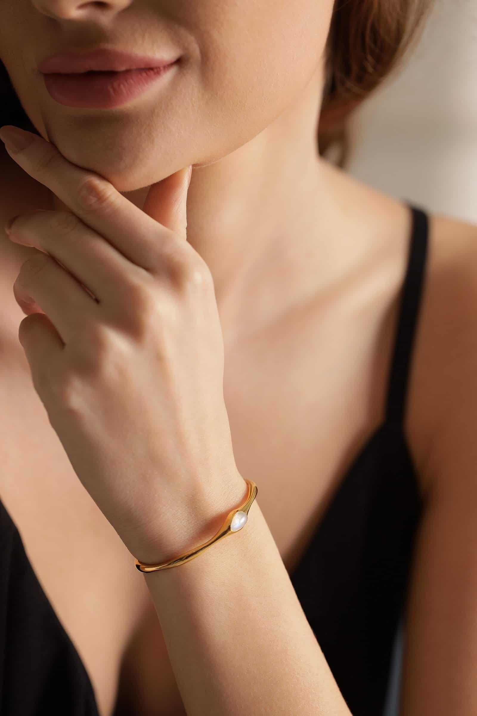 Sterling silver bracelet with a pearl detail, worn on a woman's wrist, showcasing minimal and elegan.