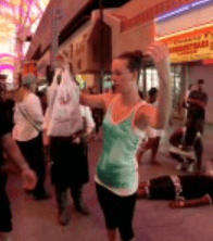 Woman holding plastic bag, street performance scene.
