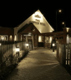 Night view of a lit restaurant entrance.