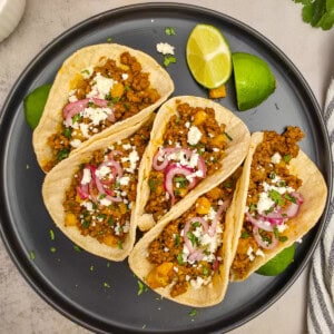 Quick Tacos Al Pastor on plate with lime wedges.