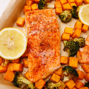 Baked salmon fillets, roasted butternut squash, and broccoli straight out of the oven on a sheet pan.