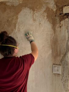 Restoration of a damaged wall at Singing Feather Ministries for community outreach.