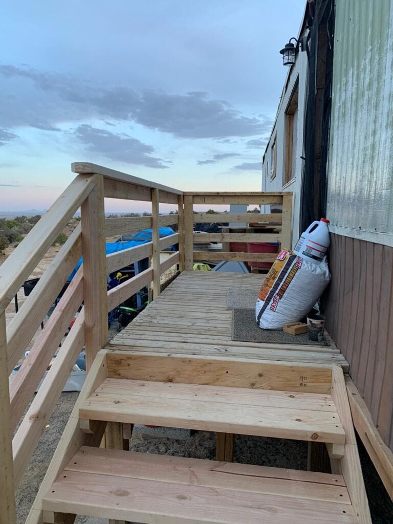 Handcrafted wooden porch under construction at Singing Feather Ministries, showcasing local building initiatives.