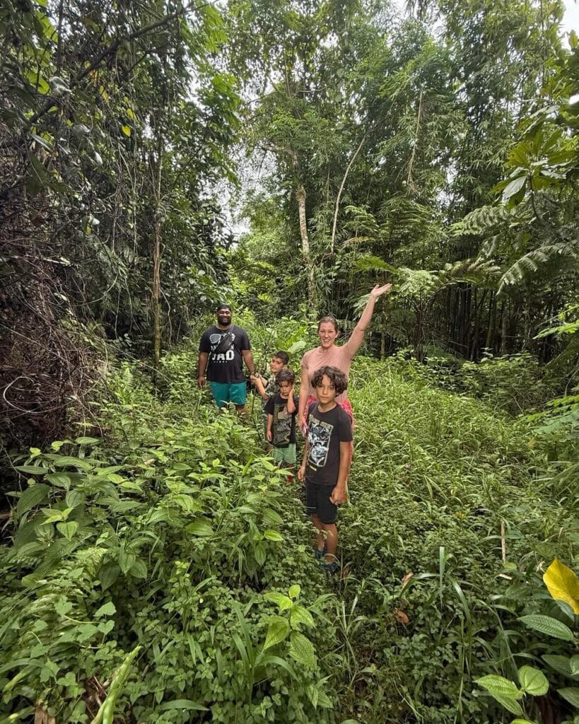 Exploring the jungle with Singing Feather Ministries, children and adults enjoying nature and community building in a lush green forest setting.