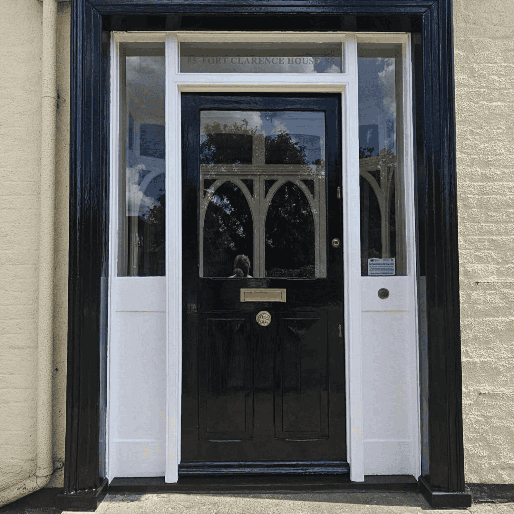 Black front door with glass panels and white frame at Port Clarence House by SMG Building Solutions
