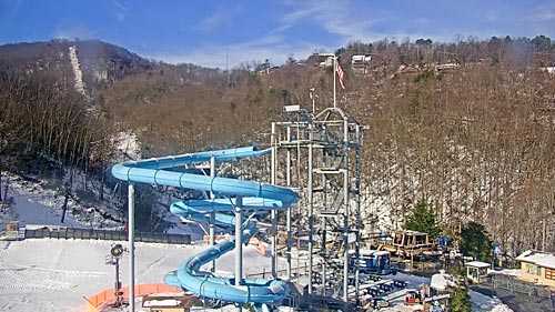 Outdoor ski resort water slide with snowy mountain landscape, ideal for family winter fun and adventure.