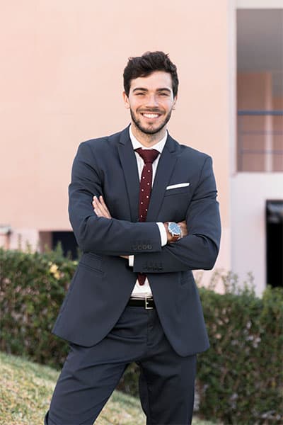 Business professional man in suit smiling outdoors at Softlogic Australia office.