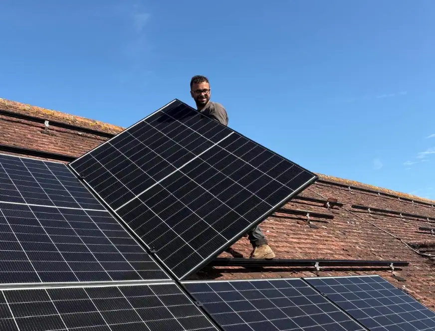 Expert solar panel installer fitting high-efficiency solar panels on a residential roof in Kent, showcasing renewable energy solutions for sustainable living.